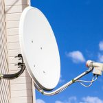 Satellite dish mounted on the wall of a private house