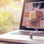 Shopping online concept - Parcel or Paper cartons with a shopping cart logo in a trolley on a laptop keyboard. Shopping service on The online web. offers home delivery.